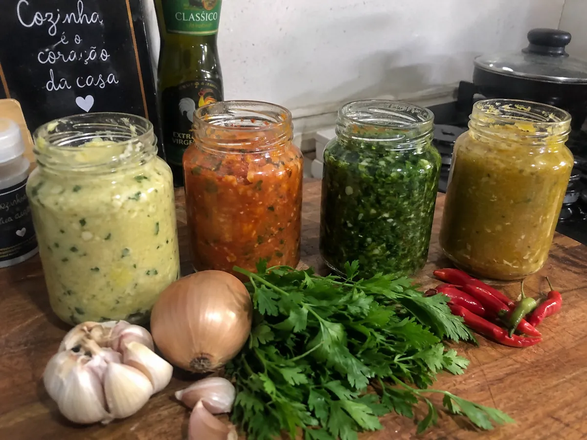 Quatro potes de tempero em pasta prontos para a semana, com alho, cebola e cheiro-verde