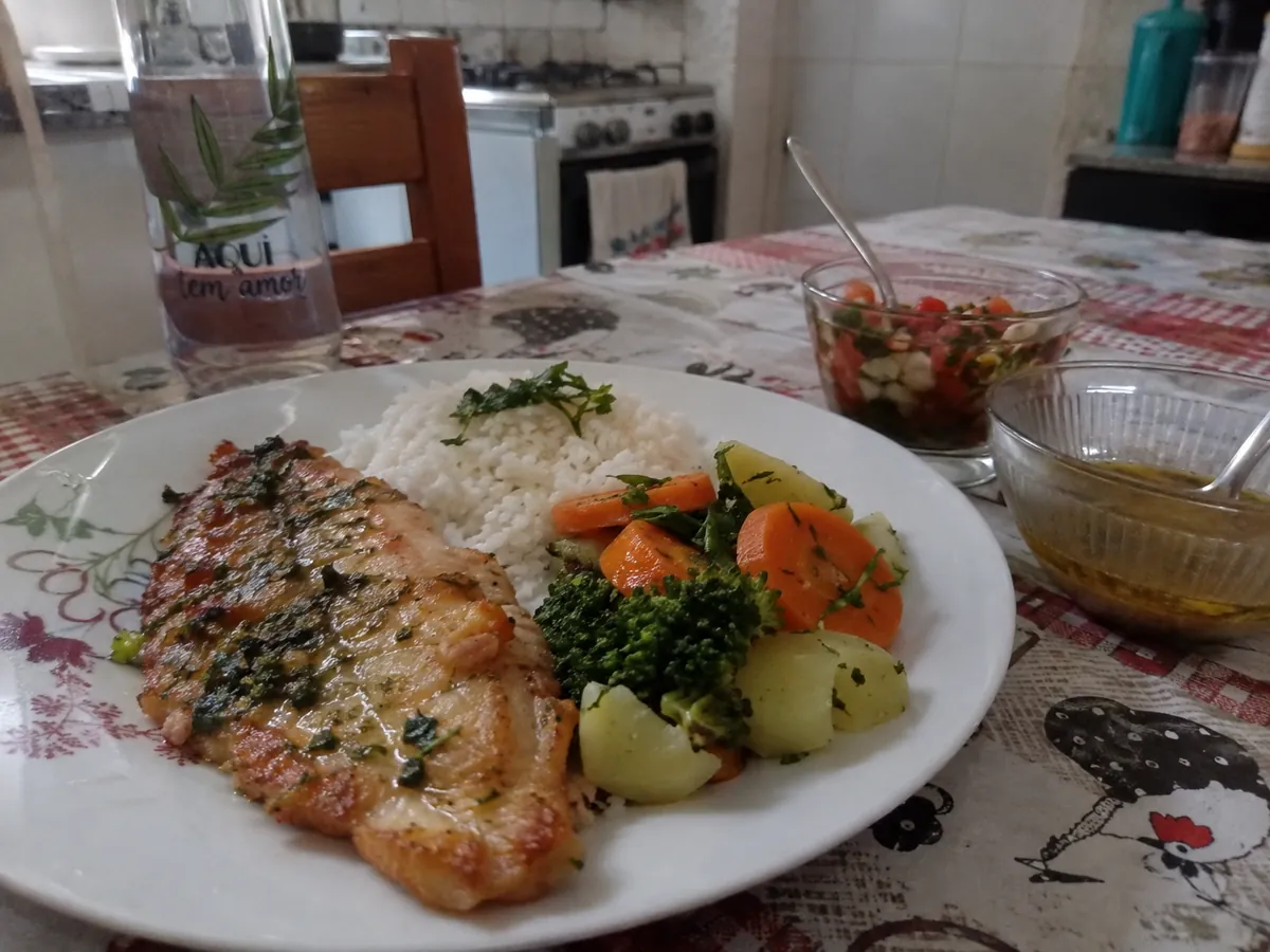 Prato de peixe grelhado com arroz e legumes temperados com ervas